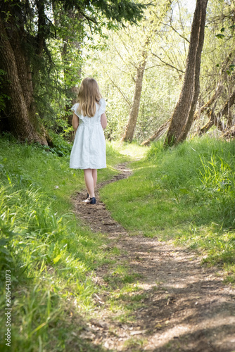 Little girl walking alone through forest path, depersonalization