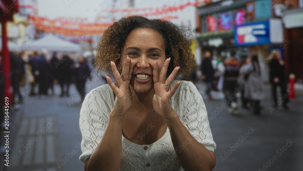 Fototapeta premium Woman cups hands to mouth calling to passersby on a busy outdoor street market; joy connection community.