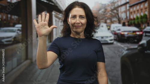 Photography Woman with exposed hand pointing thumb over shoulder and waving on a street with parked cars and shop windows and reflections; farewell calm