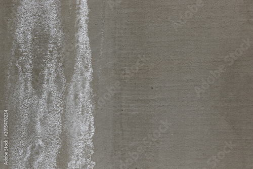 Foto white efflorescence salt deposits on a grey concrete wall.