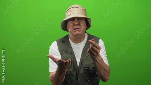 Bild auf Leinwand Man fisherman wearing bucket hat and fishing vest shows palms up begging gesture and folds hands in plea in studio; pleading resignation