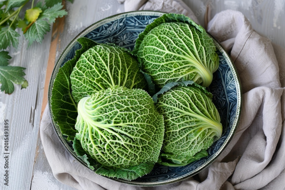 Fototapeta premium Savoy cabbages are presented in a bowl, ready for culinary use, embodying freshness and healthy eating