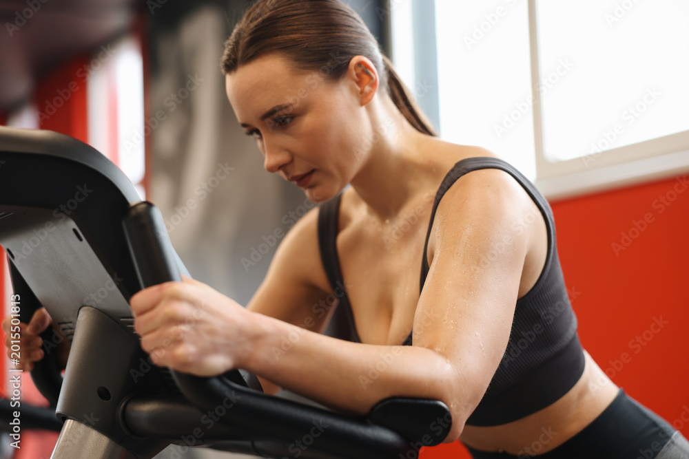 Fototapeta premium Athletic woman with sweat on her body training in gym