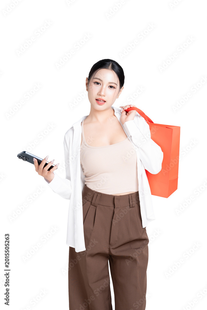 Naklejka premium Happy young Asian woman holding shopping bags and using application for choosing product on your mobile phone with enjoyment with shopping online concept. on transparent background.