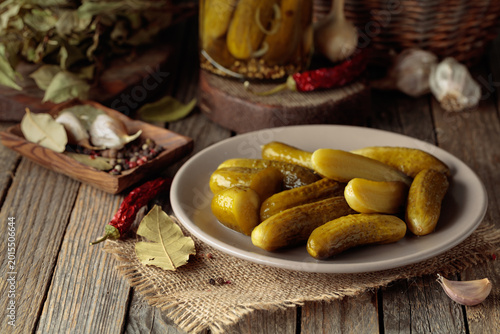 Fotografi Homemade canned gherkins on a rustic wooden background.