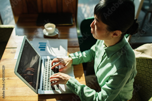 Businesswoman typing on laptop at coffee shop