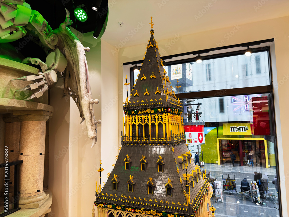 Naklejka premium Detailed LEGO tower model display in a London, UK toy store window with ornate gothic architecture and shoppers on the street below