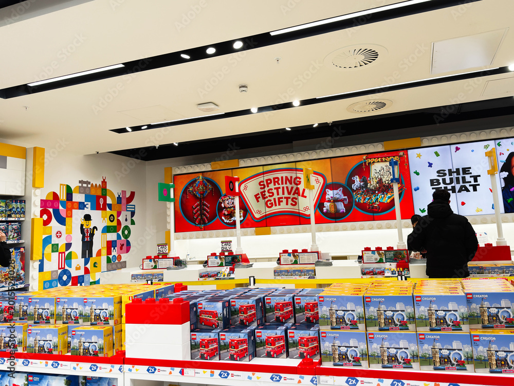 Fototapeta premium Busy LEGO store in London UK with shoppers browsing spring festival gifts and boxed sets on colorful shelves