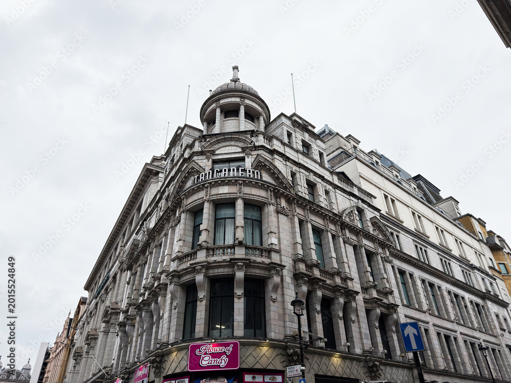 Fototapeta premium Historic ornate commercial Trocadero building facade in London UK with classical architecture and domed corner tower above a House of Candy storefront