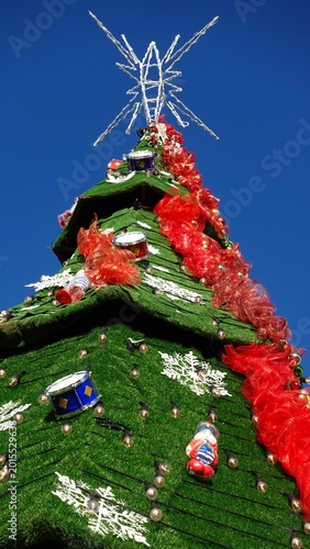 Cuadro en lienzo Árbol de Navidad decorado con bolas de plástico brillantes y luces festivas en ambiente acogedor, representando celebraciones navideñas, tradición familiar y decoración típica de fin de año
