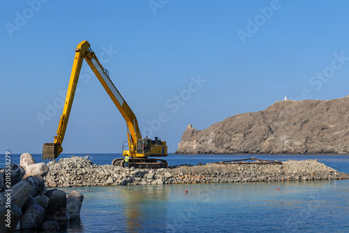 Obraz na plátne Marine construction for new artificial islands featuring heavy excavator, coasta
