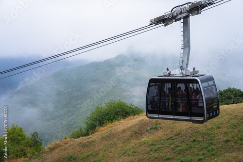 Slika na platnu Ropeway cabin gliding above mountainous terrain, offering scenic aerial views, adventure tourism, and a thrilling perspective of rugged natural landscapes