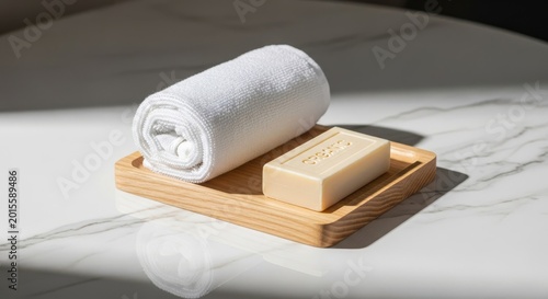 Elegant hotel amenities set including a rolled white towel, organic soap bar, and wooden tray on a marble desk for hospitality branding, boutique, design, minimalist