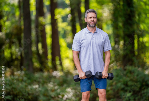 Biceps muscle. Strong triceps. Man exercising with dumbbell. Man athlete lifting dumbbell. Strong man sport exercise. Outdoor workout. Sport athlete man with dumbbell. Healthy lifestyle, copy space
