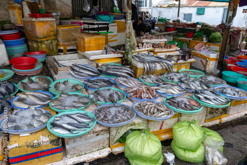 Obraz na plátně A vendor displays a variety of fresh fish on ice at a bustling market in Da Lat, Vietnam