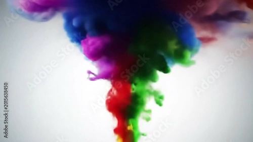 Studio eye level shot of multi-colored blue, purple, and green ink plumes rising and twisting in water.