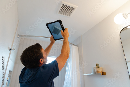 Foto A home inspector inspecting a bathroom fan