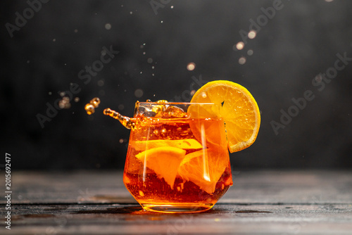 Foto Horizontal view of fresh delicious juice in a glass with orange limes on dark ta