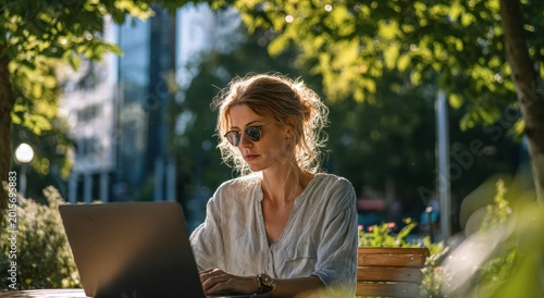 Woman sitting outdoors with laptop in natural lighting conditions outdoor setting woman with laptop
