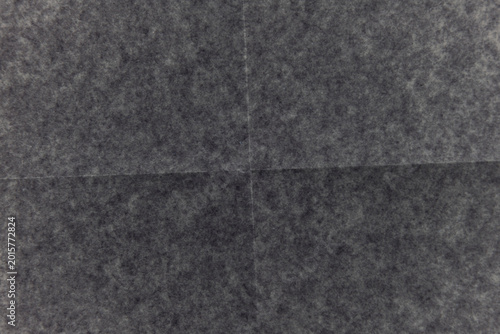Dark crumpled paper texture with visible fold marks, distressed wrinkles and grunge surface. Abstract monochrome paper background with aged dirty texture, creased sheet effect.