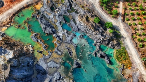 Foto Aerial view of a rocky quarry with turquoise water and lush greenery