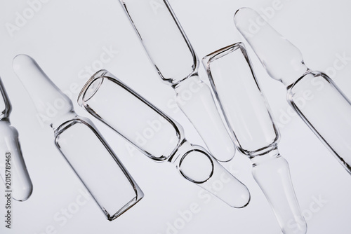 Transparent glass ampoules and vials symbolizing medical science and pharmaceutical research