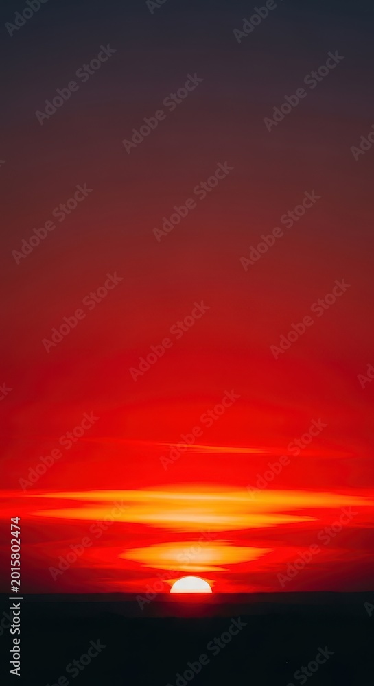 Fototapeta premium Intense red and fiery orange colors dominate the sky as the sun breaks the horizon, creating a spectacular natural dawn display, twilight, dramatic, backdrop