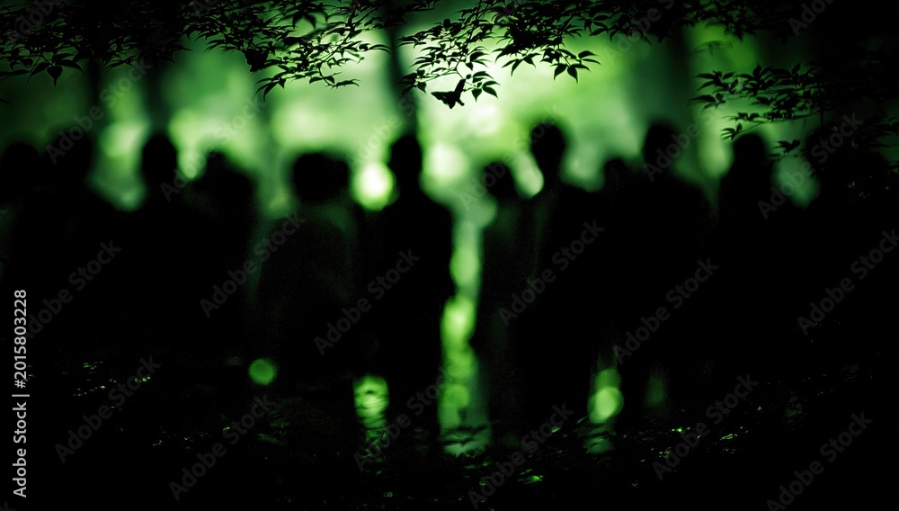 Fototapeta premium Silhouetted figures emerge from a dark, emerald-green, misty forest