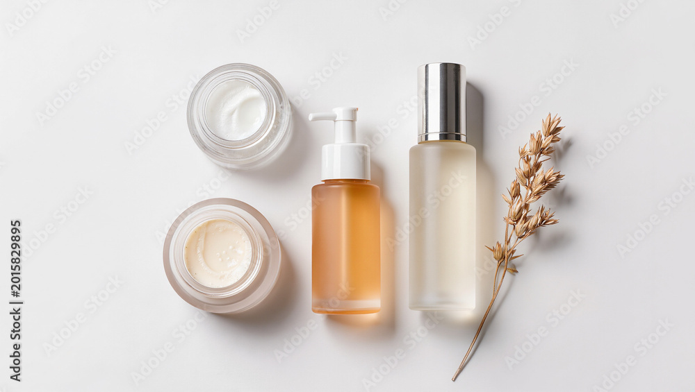 Fototapeta premium Korean skincare beauty product set cream toner serum flat lay white background dried grass, Natural organic K-beauty skincare flatlay with moisturizer pump bottle and dried botanicals
