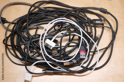 Mixed charging cables on a wooden surface
