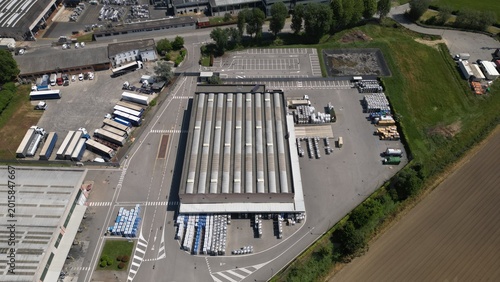 Industrial Complex: An aerial view showcases a bustling industrial complex, depicting the various aspects of modern industry with structures, transport vehicles, and extensive open spaces.