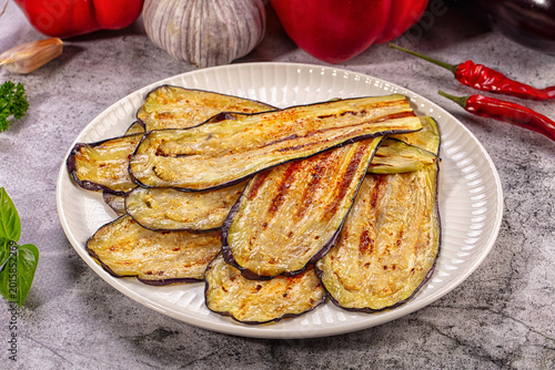 Fotografie Grilled eggplant slices appetizer with fresh vegetables and herbs on gray backgr