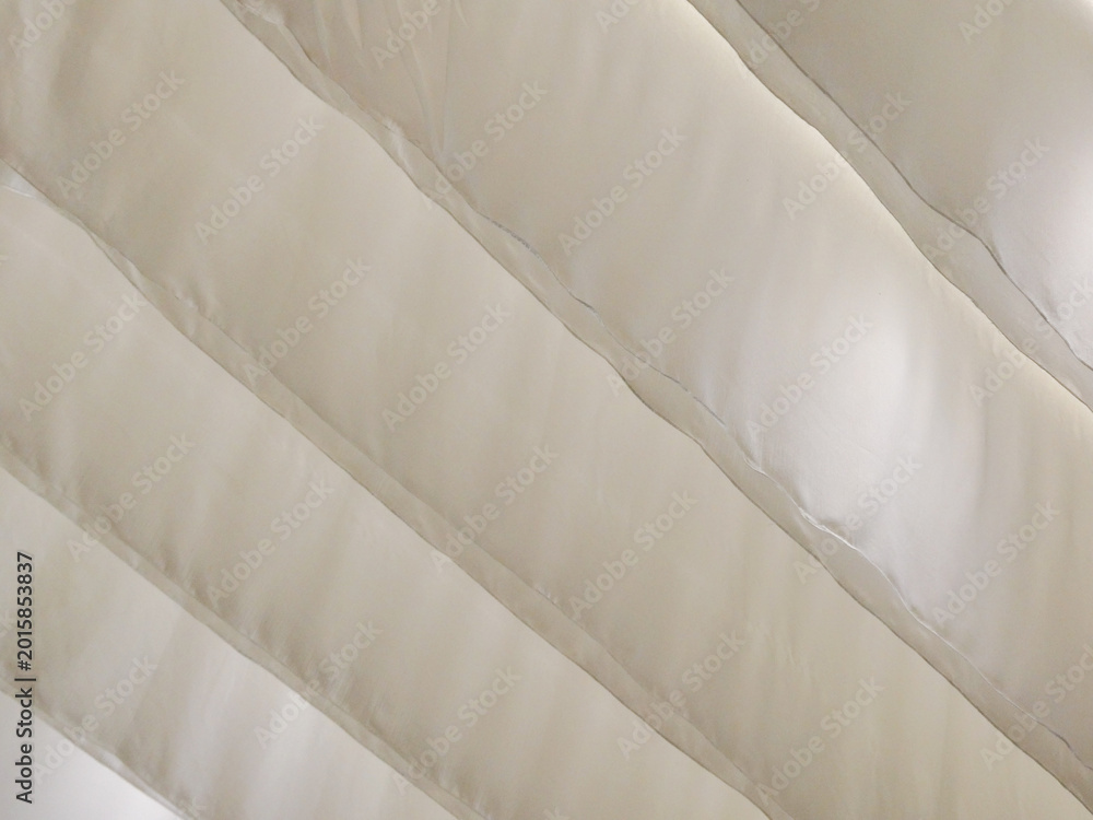 Fototapeta premium Close Up View of Cream Colored Quilted Fabric with Diagonal Stitching and Soft Texture