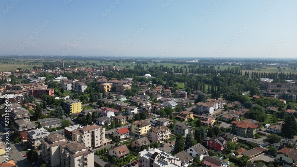 Fototapeta premium Aerial Cityscape Under Clear Skies: A vibrant scene, showcasing a city's architectural diversity under a bright, cloudless sky, promising endless possibilities. Pantigliate, Milan, Italy