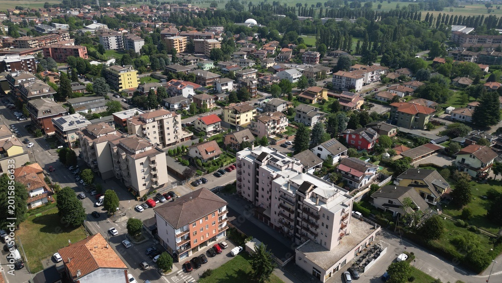 Fototapeta premium Urban Landscape: A stunning aerial view showcases a vibrant cityscape, with an intricate network of buildings and infrastructure seamlessly integrated into a thriving community. Pantigliate, Italy