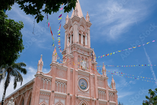 Pink Cathedral in Da Nang, Vietnam under blue sky with colorful festival flags
