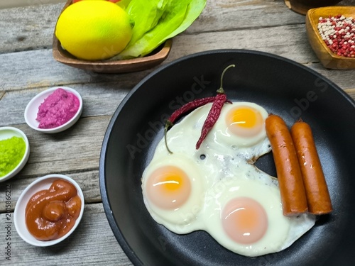 Foto delicious appetizing breakfast of fried eggs and sausages on a frying pan