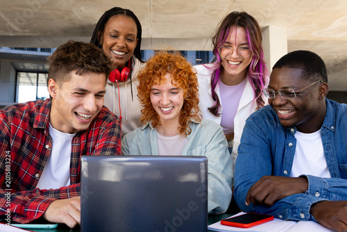 Tableau sur toile Happy students watching laptop at university campus: multi-ethnic group project