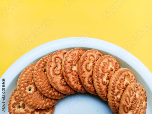 Golden Brown Biscuits on Plate Top View with Copy Space on Yellow