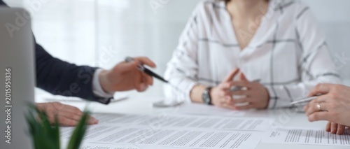 Tableau sur toile Business professionals reviewing contracts and paperwork in a meeting, pointing