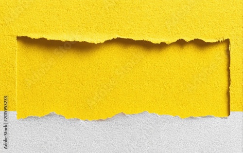 Bright yellow paper torn to reveal a lighter shade of yellow underneath