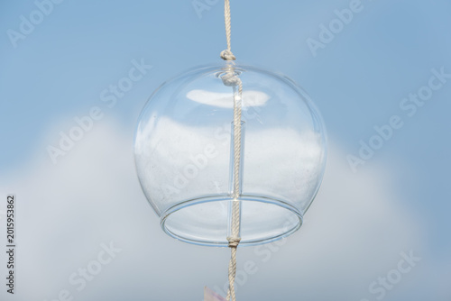 Konstfotografi Traditional Japanese glass wind chime hanging against a beautiful blue sky with white clouds