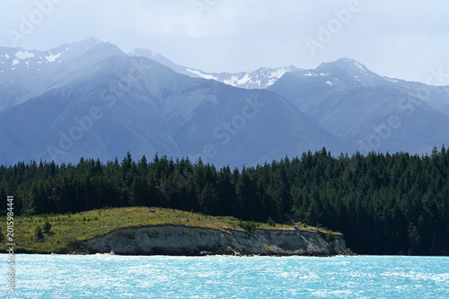 Picturesque Turquoise Lake Shore with Evergreen Forest and Majestic Snow-Dusted Mountains