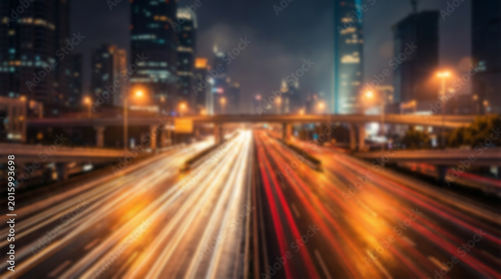 Fototapeta premium City street at night with car light trails and blurred buildings, long exposure photography