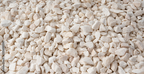 Crushed quartzite pebble textured background, white decorative marble stones close up