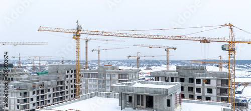 Tablou pe pânză Snow blankets construction sites with towering cranes