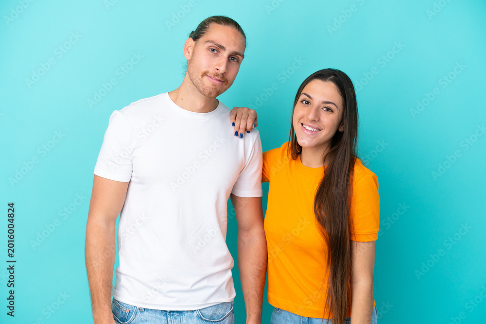Fototapeta premium Young caucasian couple isolated on blue background happy and laughing