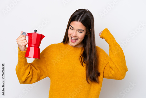Foto Young Brazilian woman holding coffee pot isolated on white background celebratin