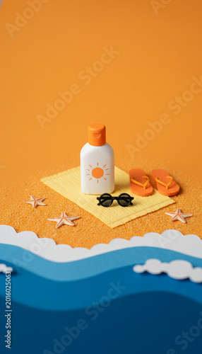 Miniature beach scene with sunscreen, sunglasses, and flip-flops on sand and waves, symbolizing summer vacation and sun protection
