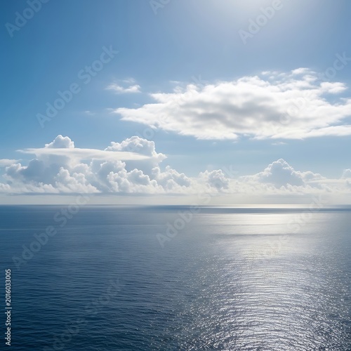 Ocean view with clouds and sunlight reflecting on the water surface.